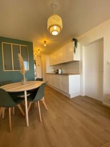 a room with a table and chairs and a kitchen at Appart cosy Carnon-plage in Mauguio