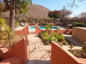 a backyard with a swimming pool and a fence at Pilanesberg View Guest house in Mabele-a-podi