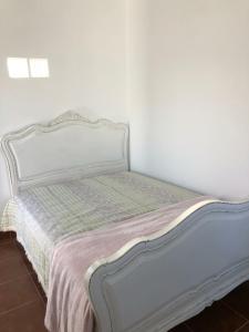 a white bed in a white room with a bedspread at Villa Mon Bonheur in Altura