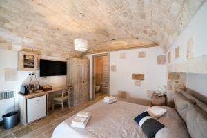 a bedroom with a bed and a desk in a room at Resort Trulli San Leonardo in Alberobello
