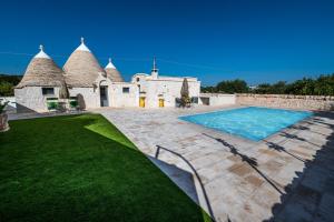 an external view of a house with a swimming pool at Resort Trulli San Leonardo in Alberobello