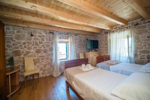 a bedroom with two beds and a stone wall at Vintage house Kolocep in Koločep