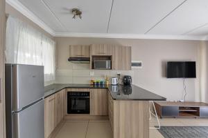 a kitchen with a refrigerator and a counter top at 1 Bed in Chartwell in Chartwell