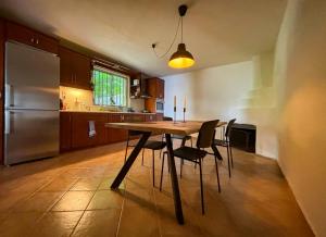 a kitchen with a table and chairs and a refrigerator at Villa Oraia Verga Kalamata in Kalamata