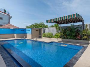 a swimming pool in front of a building at The Kanjeng Suites Kuta Galeria - Bali in Kuta