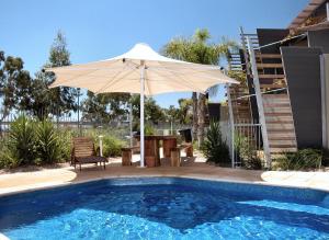 
a white umbrella sitting in the middle of a pool at Majestic Oasis Apartments in Port Augusta
