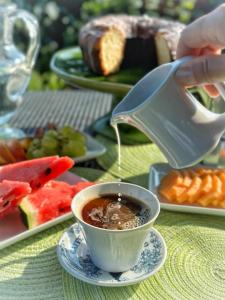 a person pouring coffee into a cup on a table at Soleevino B&B - Exclusively for Adults in Greve in Chianti +71 photos