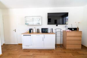 a kitchen with white appliances and a counter top at Cozy Studio Einigen in Einigen