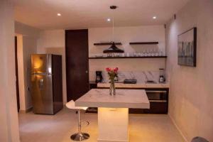 a kitchen with a table with a vase of flowers on it at MID-498 Centro in Mérida