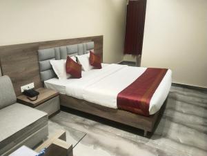 a bedroom with a large bed and a couch at Hotel Dolly in Siliguri +16 photos