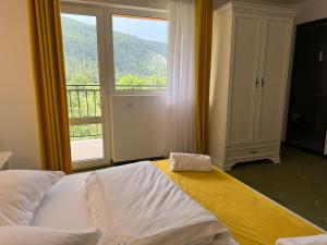 a bedroom with a bed and a large window at Pensiunea Mary in Moieciu de Jos +161 photos