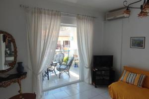 a bedroom with a bed and a sliding glass door at White Beach Appartment in Yerakiní