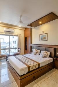 a bedroom with a large bed and a large window at Hotel Plaza Inn, Ajmer in Ajmer