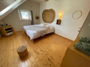 a bedroom with a bed and a wooden floor at Gîte Les Eaux du Moulin piscine chauffée et jacuzzi in Vittefleur +67 photos