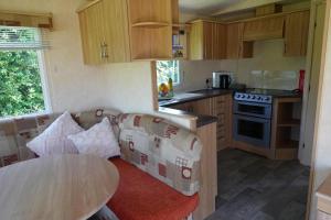 a kitchen with a couch and a table in a room at Quiet Equestrian Retreat - Sleeps 4 in Trusthorpe