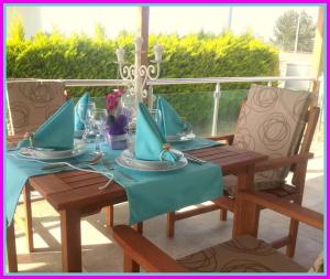 a wooden table with blue napkins on a patio at Poseidon Marine Villa in Ildır