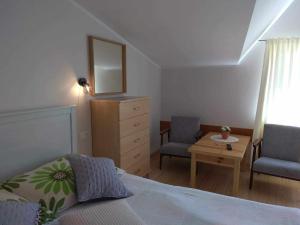 a bedroom with a bed and two chairs and a table at Apartament i pokoje na Sosnowej in Ostrowo
