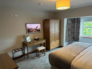 a bedroom with a bed and a desk and a window at The Brook Lodge in Galway