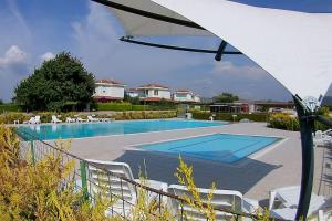 a swimming pool with white chairs and an umbrella at Poseidon Marine Villa in Ildır