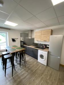 a kitchen with a table and a refrigerator at Les Pichies, T2 Gloria, centre ville in Digoin