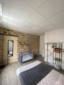 a bedroom with a bed and a brick wall at Les Pichies, T2 Gloria, centre ville in Digoin