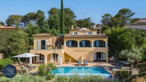 a large house with a swimming pool in front of it at Villa familiale avec vue imprenable in Saint-Raphaël