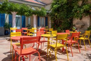 a group of tables and chairs in a patio at Hôtel de la Fontaine in Nice