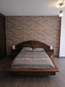 Bett in einem Zimmer mit Ziegelwand in der Unterkunft Hermoso Depto en Club Burgos Bugambilias Temixco in Temixco