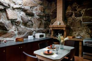 a kitchen with a table and a stone wall at Bosque Encantado in Beire