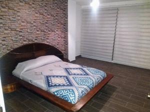 Bett in einem Zimmer mit Ziegelwand in der Unterkunft Hermoso Depto en Club Burgos Bugambilias Temixco in Temixco + 28 Fotos