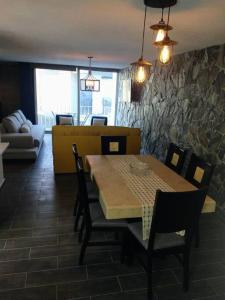 ein Esszimmer mit einem Tisch, Stühlen und einer Steinmauer in der Unterkunft Hermoso Depto en Club Burgos Bugambilias Temixco in Temixco