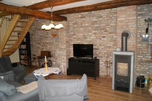 ein Wohnzimmer mit einer Ziegelwand und einem Holzofen in der Unterkunft Ferienhaus Bartelshagen 1 in Marlow