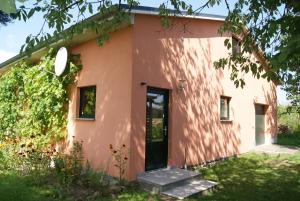 ein rosa Haus mit einer Tür und einem Hof in der Unterkunft Ferienhaus Bartelshagen 1 in Marlow