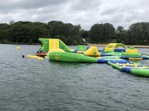 a row of inflatablelatable slides in the water at Gîte Les Eaux du Moulin piscine chauffée et jacuzzi in Vittefleur