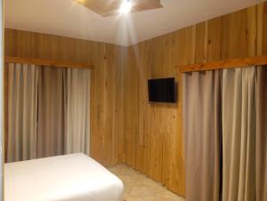 una camera da letto con un letto e una TV a schermo piatto di Le Gite du Barrage a Zaouia Ben Smine