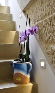 un vaso blu e bianco con fiori viola dentro di Dimora di Mezzo a Castro di Lecce Altre 25 foto