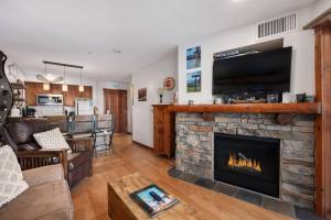 ein Wohnzimmer mit einem Kamin und einem TV in der Unterkunft RF222 Hot tub Heated garage Parking in Snowshoe
