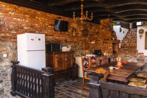 a kitchen with a wooden table and a refrigerator at Casa Soseco in Orşova