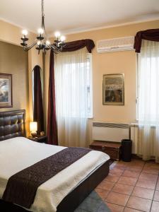 a bedroom with a large bed and windows at Verdi Apartment in Belgrade