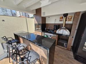 a kitchen with a counter with stools and a stove at Suíte privativa em lindo casarão in Sao Paulo
