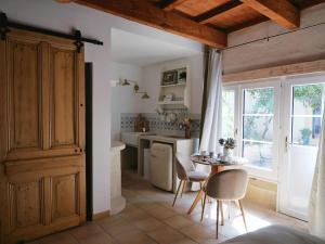 a kitchen with a table and chairs in a room at Les Songes d'Augustine in Aigues-Vives