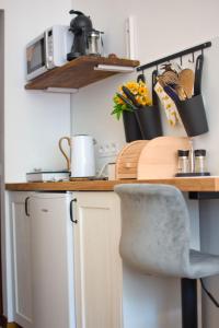 a kitchen with a counter with a table and a chair at Apartmán U dvou slunečnic in Černé Údolí