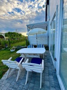 Un patio con una mesa y sillas y una sombrilla. en Bałtycka Strefa, en Władysławowo