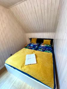 Una cama en una habitación pequeña con un edredón amarillo. en Bałtycka Strefa, en Władysławowo