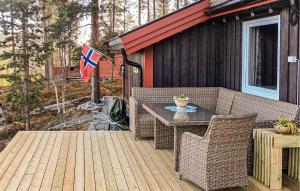 eine Terrasse mit einem Tisch, Stühlen und einer Flagge in der Unterkunft Four-Bedroom Holiday Home In Rendalen in Rendalen + 11 Fotos
