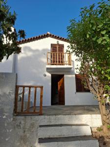 a white house with a balcony and a staircase at Villa Anna in Kalamos