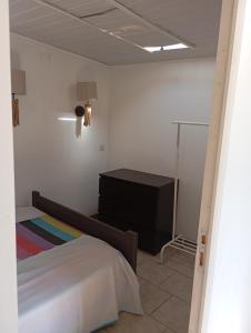 a bedroom with a bed and a dresser in it at Appartement dans Villa à marignane in Marignane