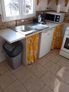 a kitchen with a sink and a microwave at Appartement dans Villa à marignane in Marignane +2 photos