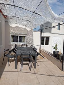 a patio with a table and chairs on a roof at Appartement dans Villa à marignane in Marignane