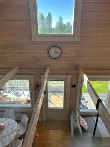 a room with a clock on the wall and a staircase at Villa Ihanus 100 m2 ja rantasauna järven rannalla in Kuusamo +38 photos